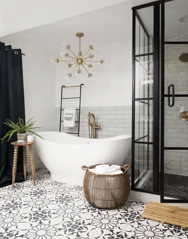 Freestanding soaking tub with brass chandelier and patterned tile