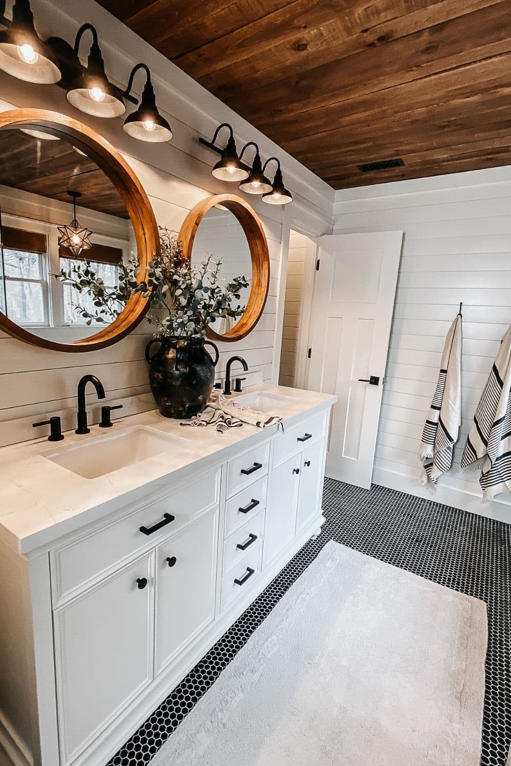 Farmhouse double vanity with wood ceiling and round mirrors